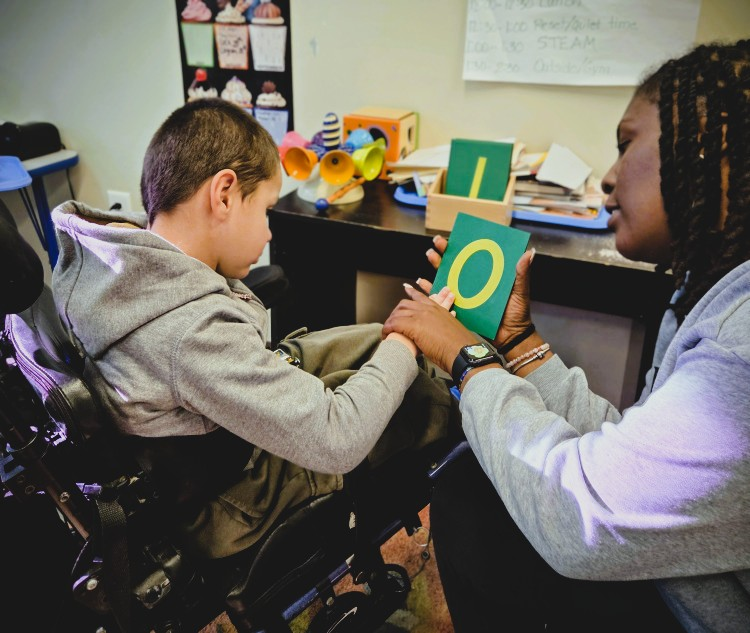 A group of children are sitting on the ground playing with clay.