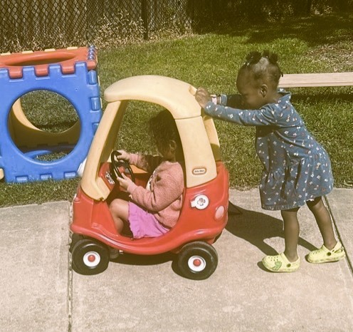 A group of children are sitting on the ground playing with clay.