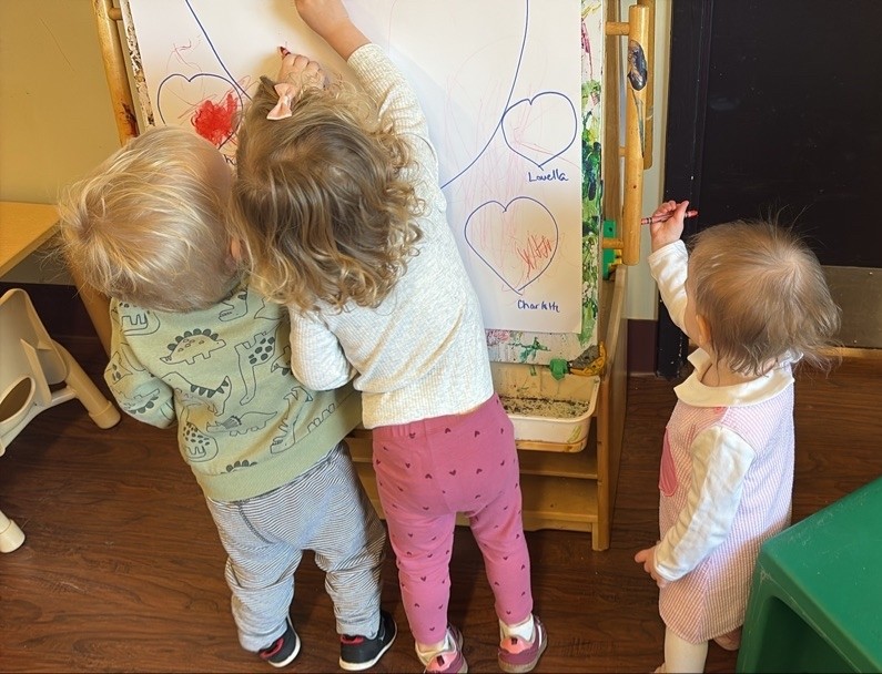 A group of children are sitting on the ground playing with clay.