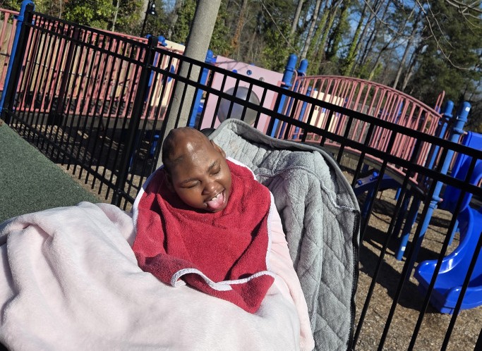 A group of children are sitting on the ground playing with clay.