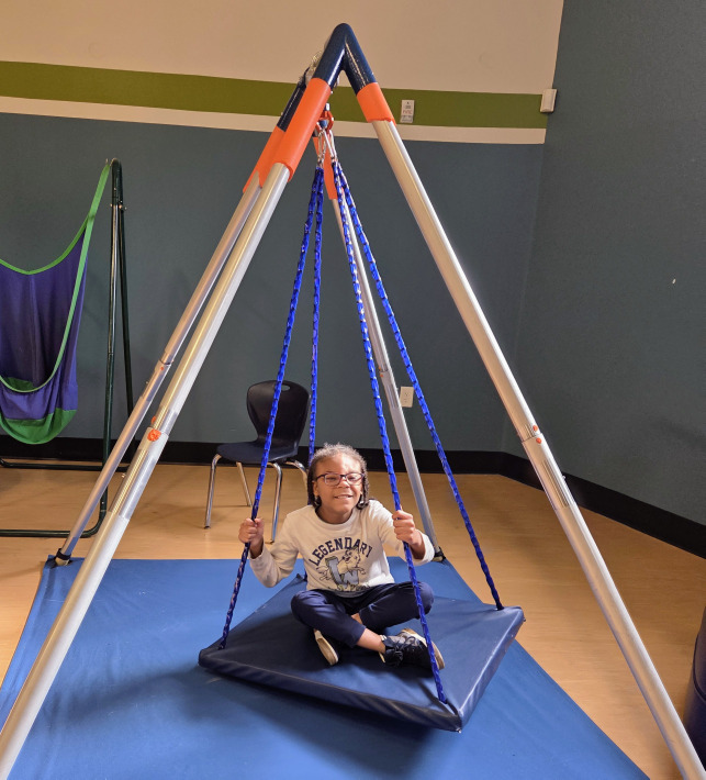 A group of children are sitting on the ground playing with clay.