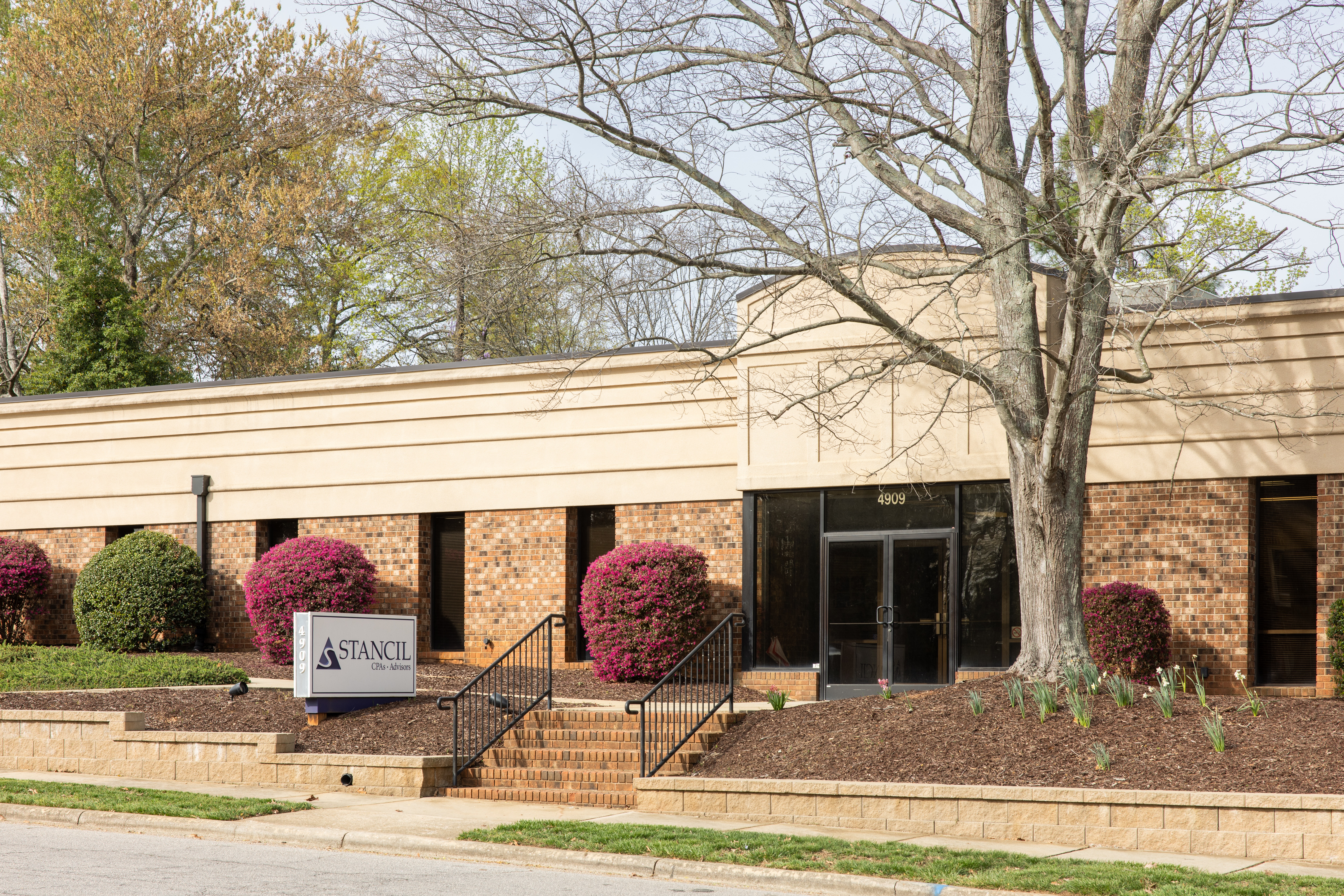 Exterior view of a brick office building with a sign reading 'Stancil'.