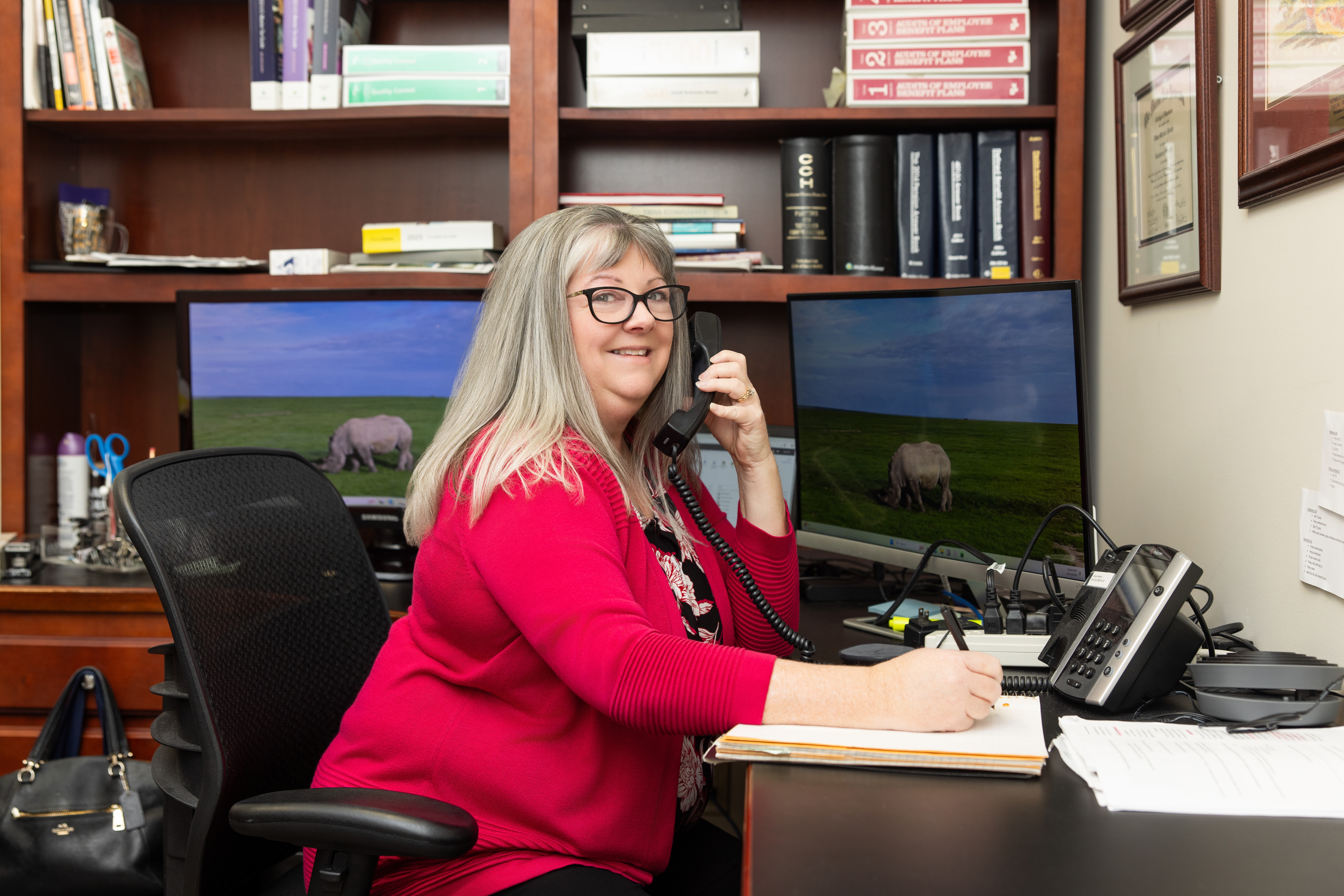 Smiling person organizing mail in an office setting