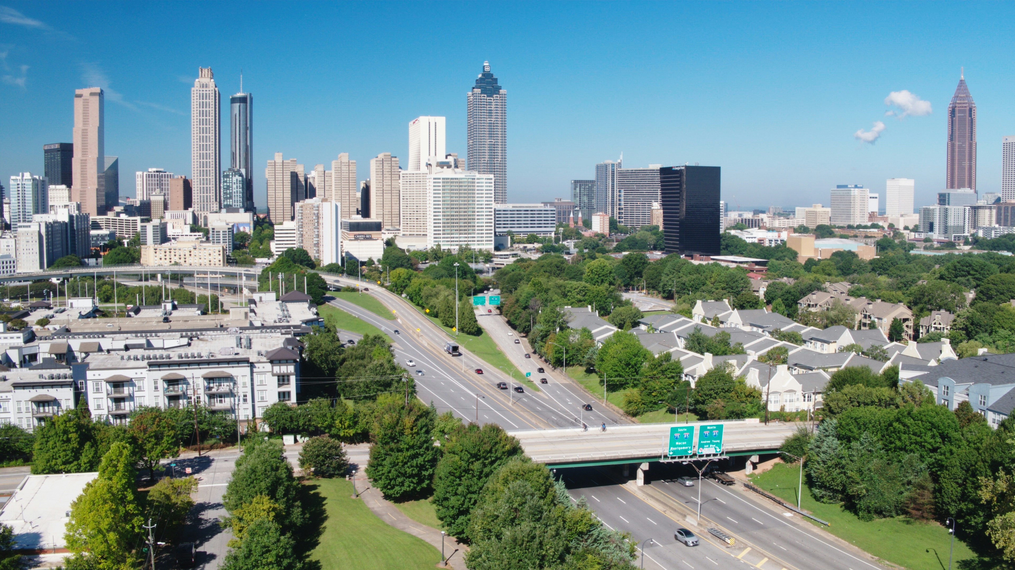 Aerial view of a cityscape with skyscrapers and a highway in the foreground