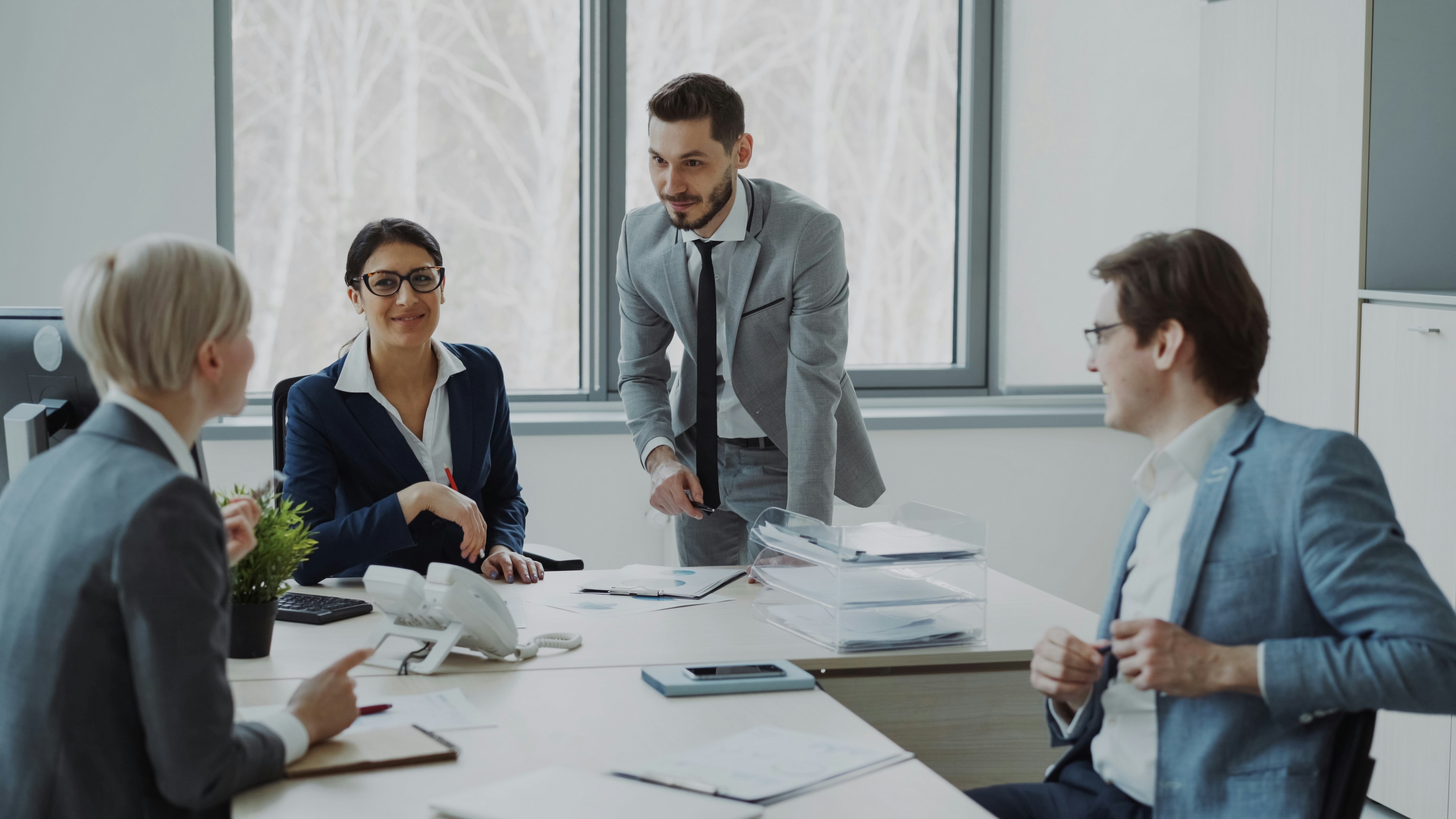 Business meeting with four professionals in a modern office setting