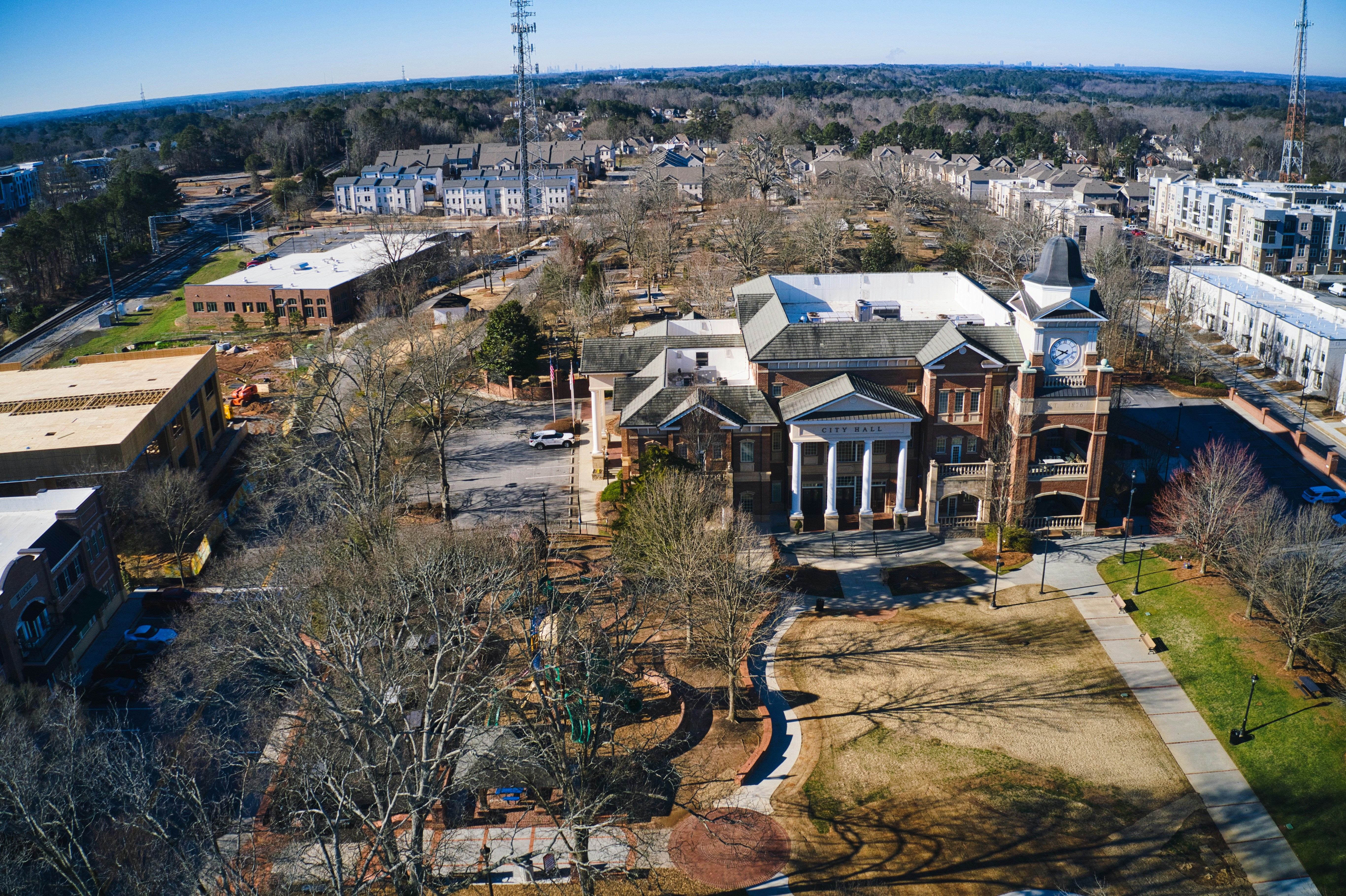 Aerial view of a town center with a prominent clock tower and surrounding buildings.