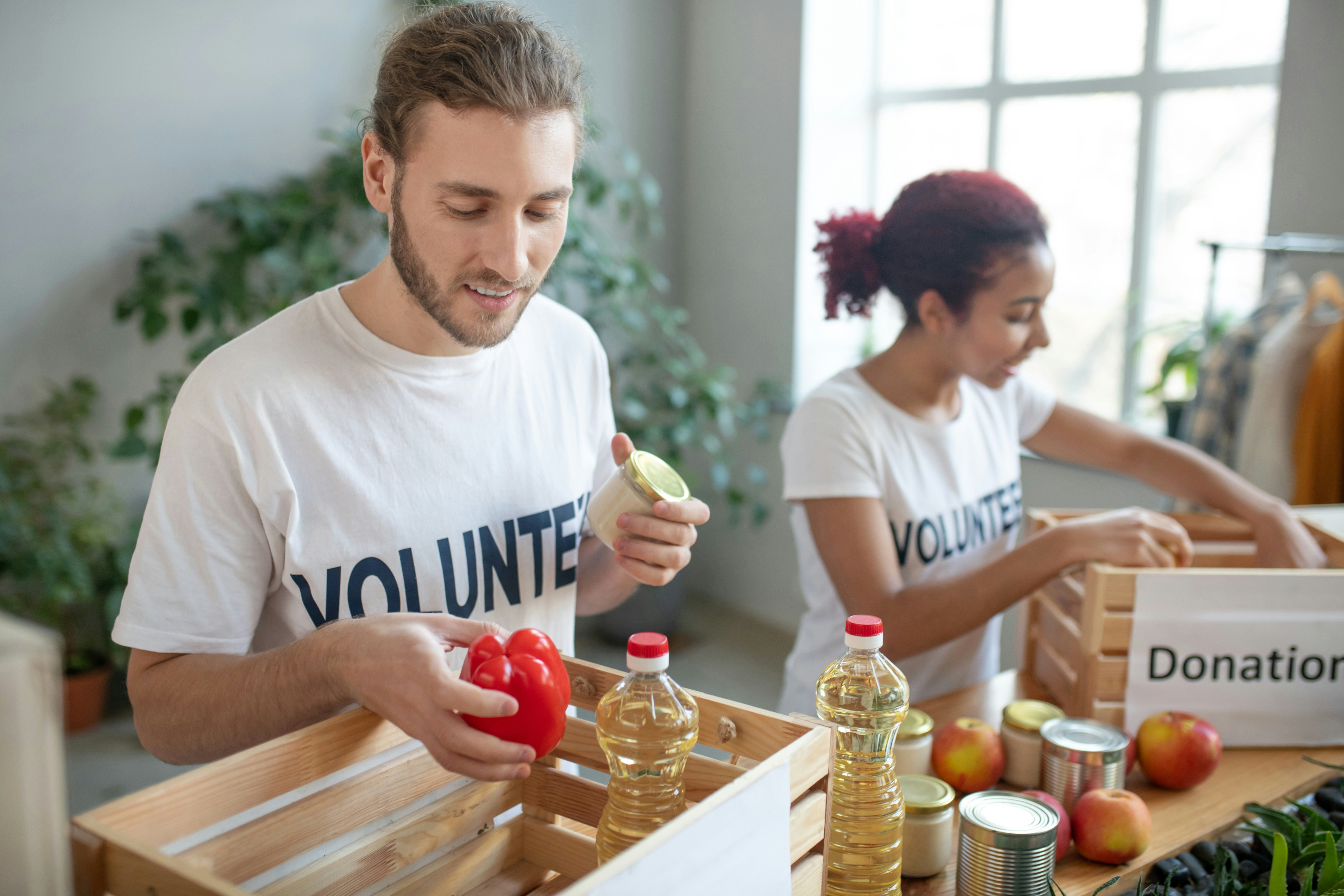 Volunteers sorting food donations into wooden crates