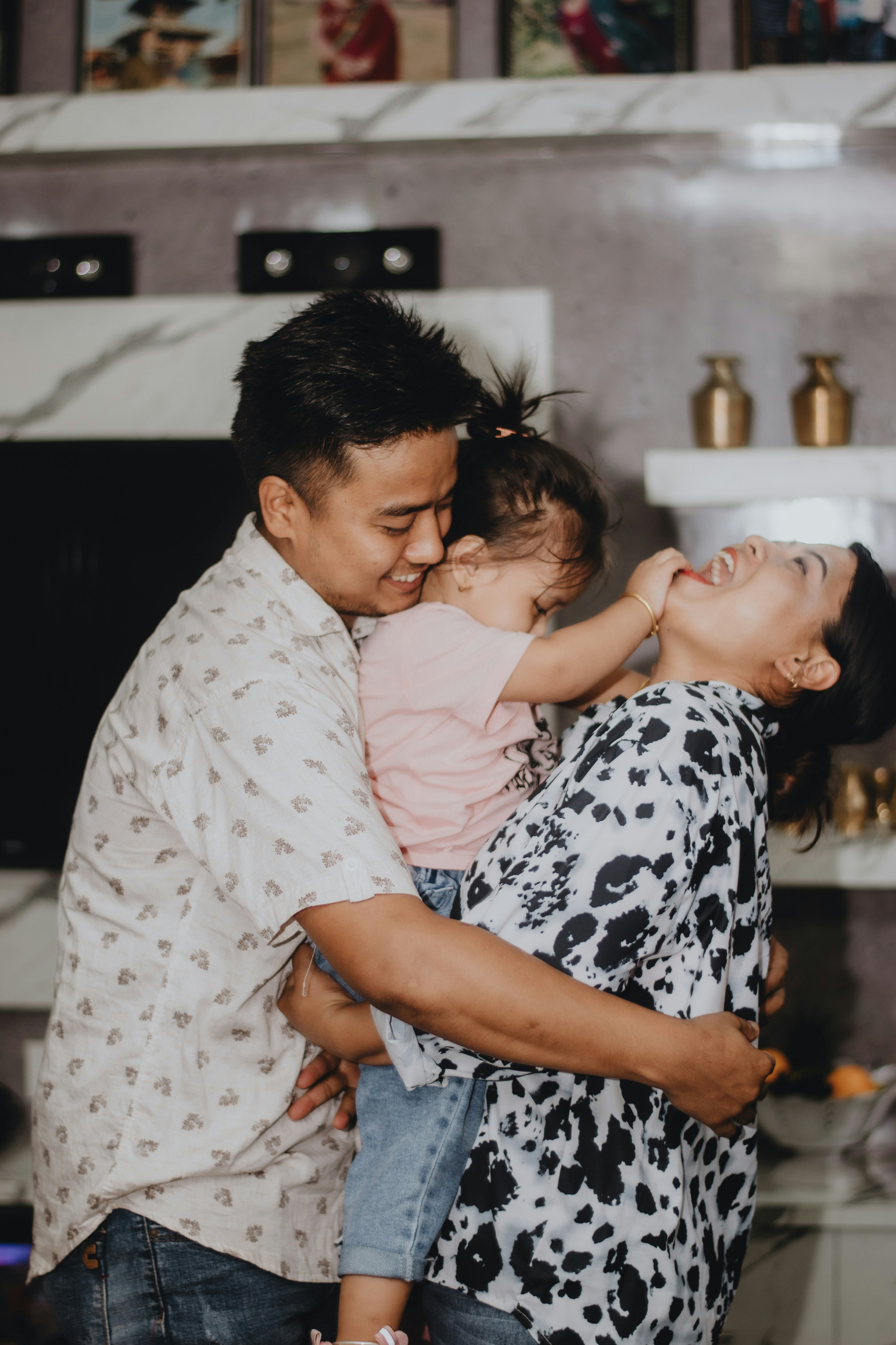 Family laughing and embracing in a living room setting