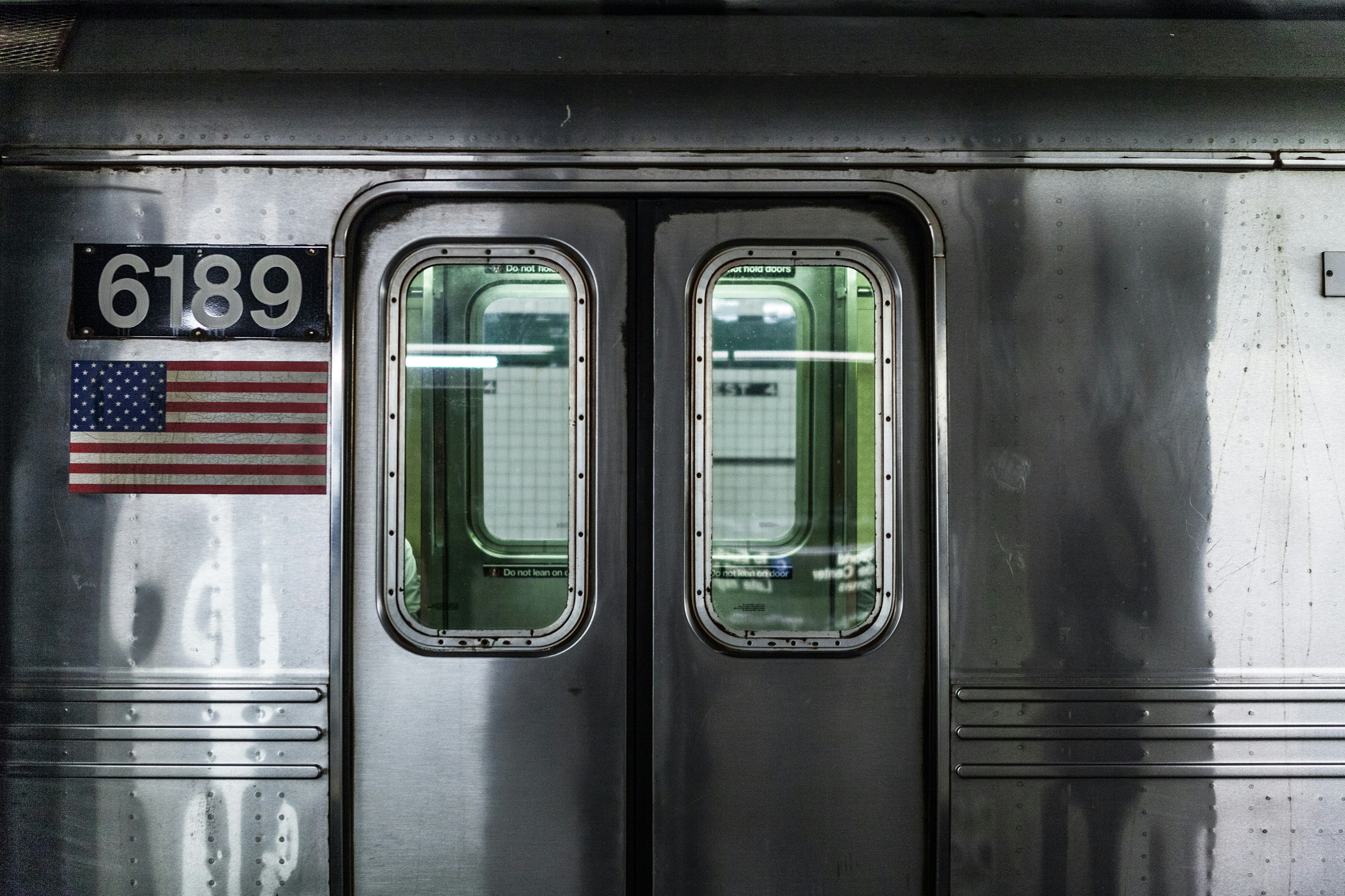 Closed doors of a subway train with an American flag and number 6189