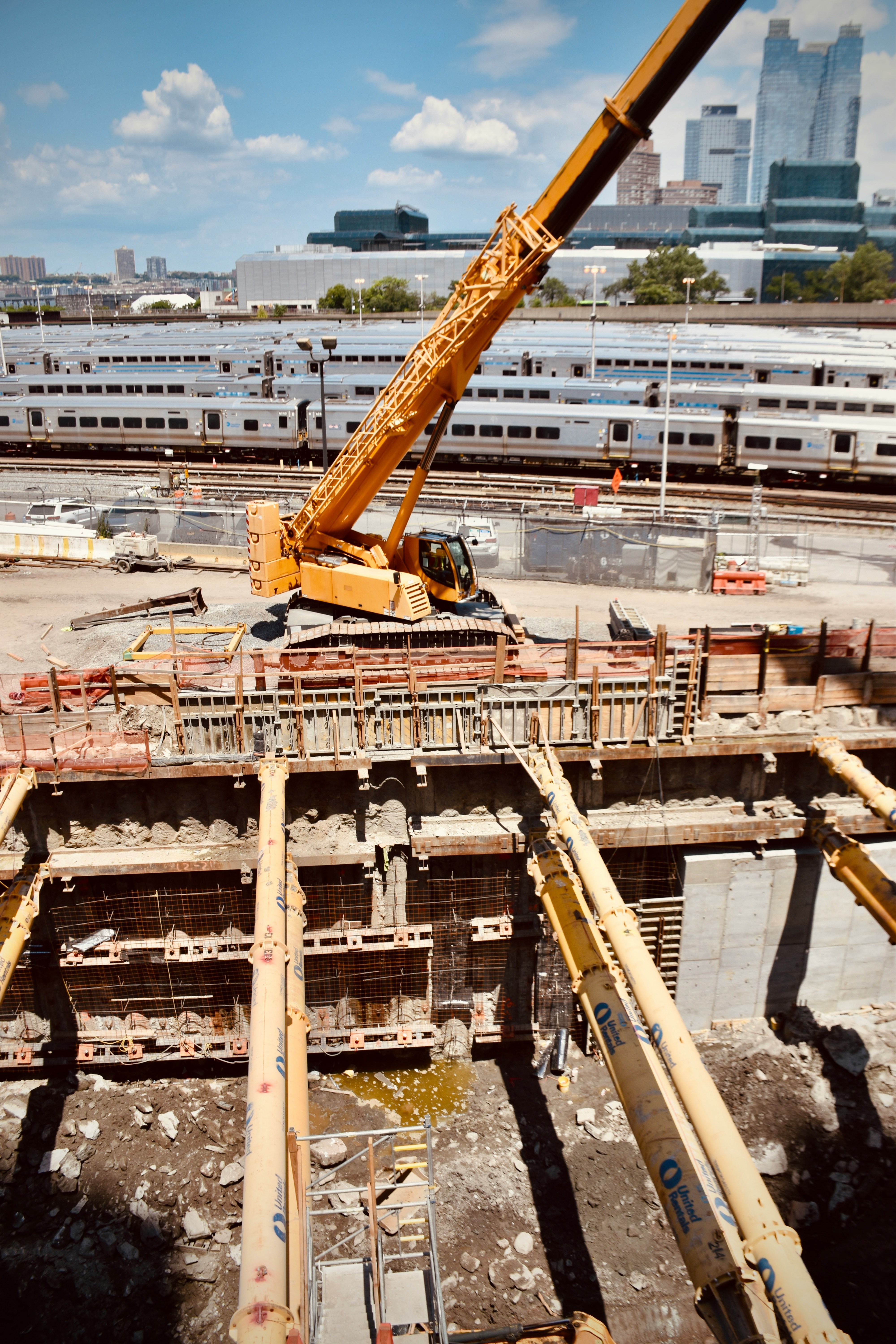 Construction site with a crane and railway tracks in the background