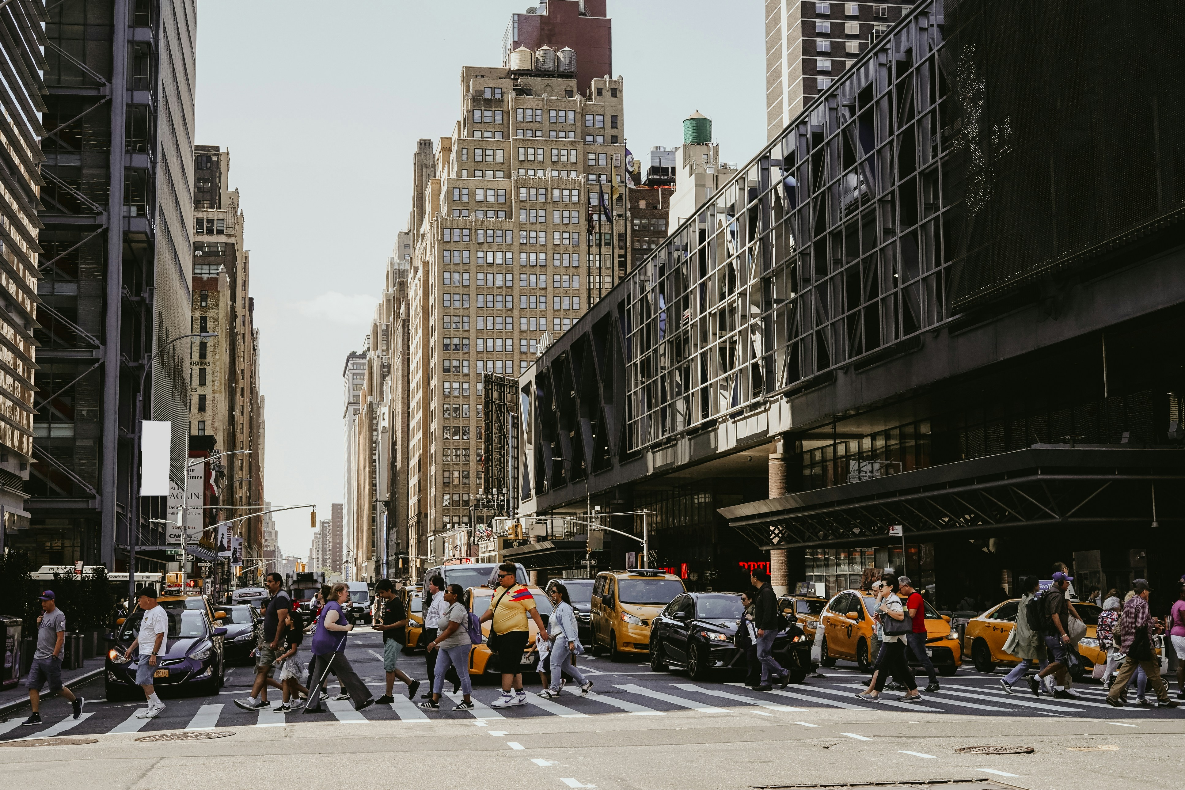 Busy city street with pedestrians and yellow taxis in an urban area