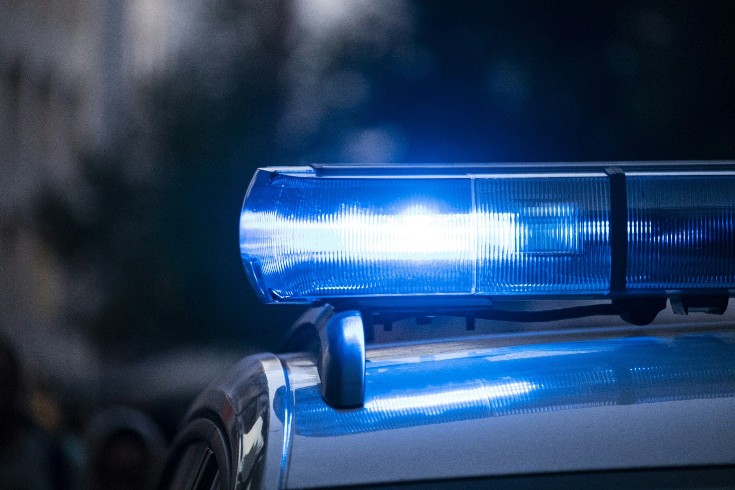 Close-up of a police car's flashing blue lights at night
