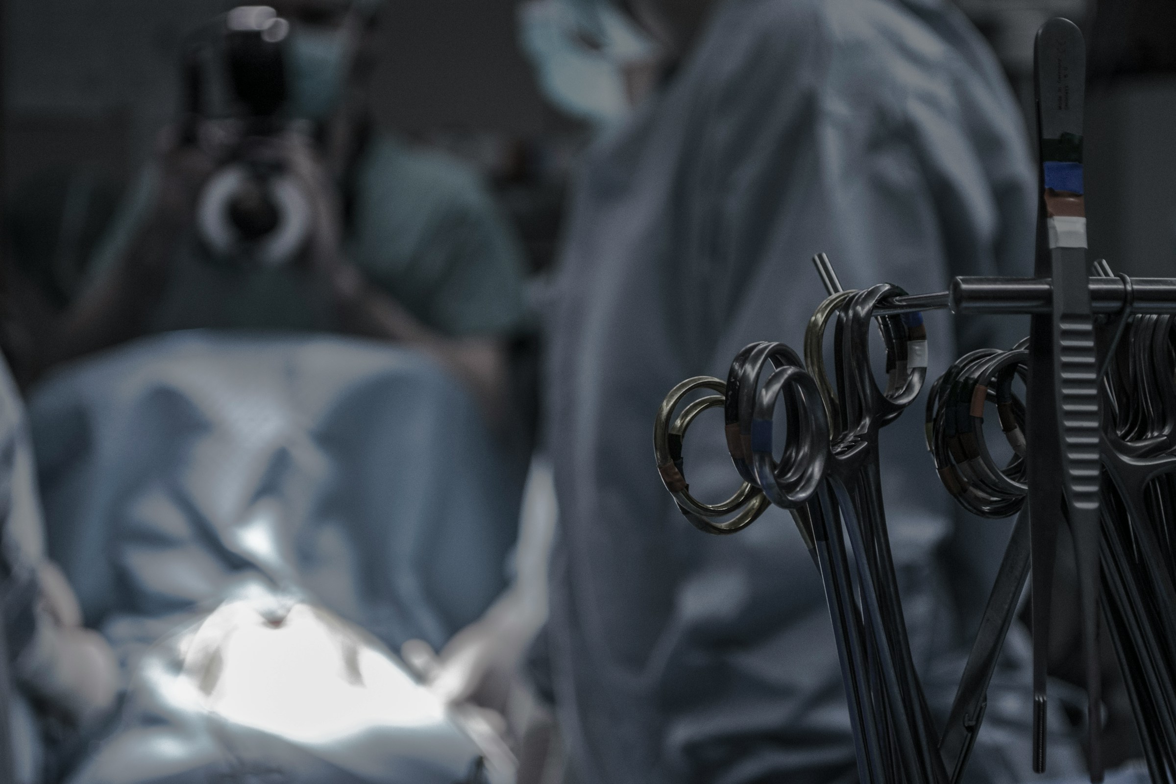 Surgical instruments in focus with blurred medical team in the background