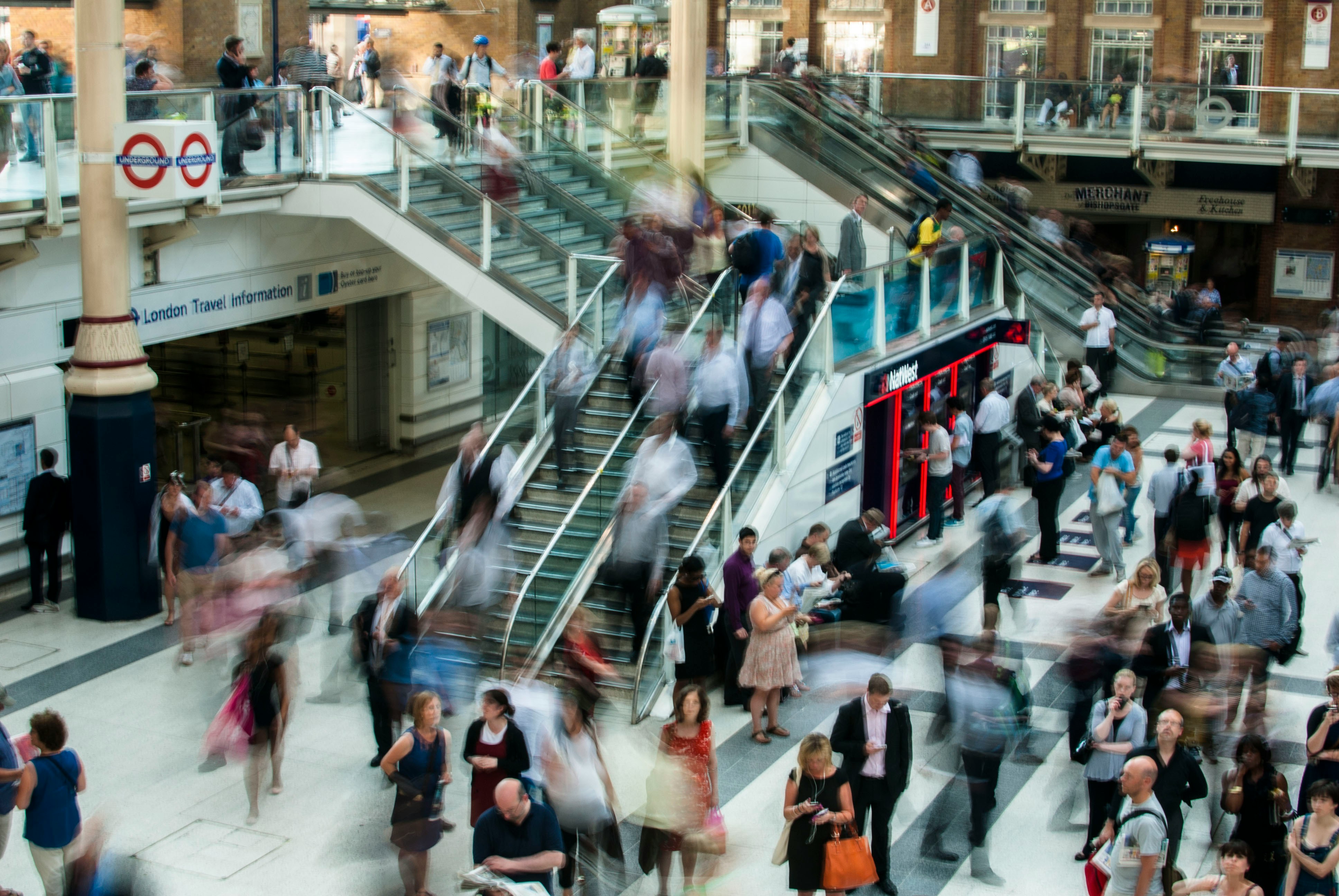 Driver’s hands on a steering wheel inside a car, driving on a rural road.
