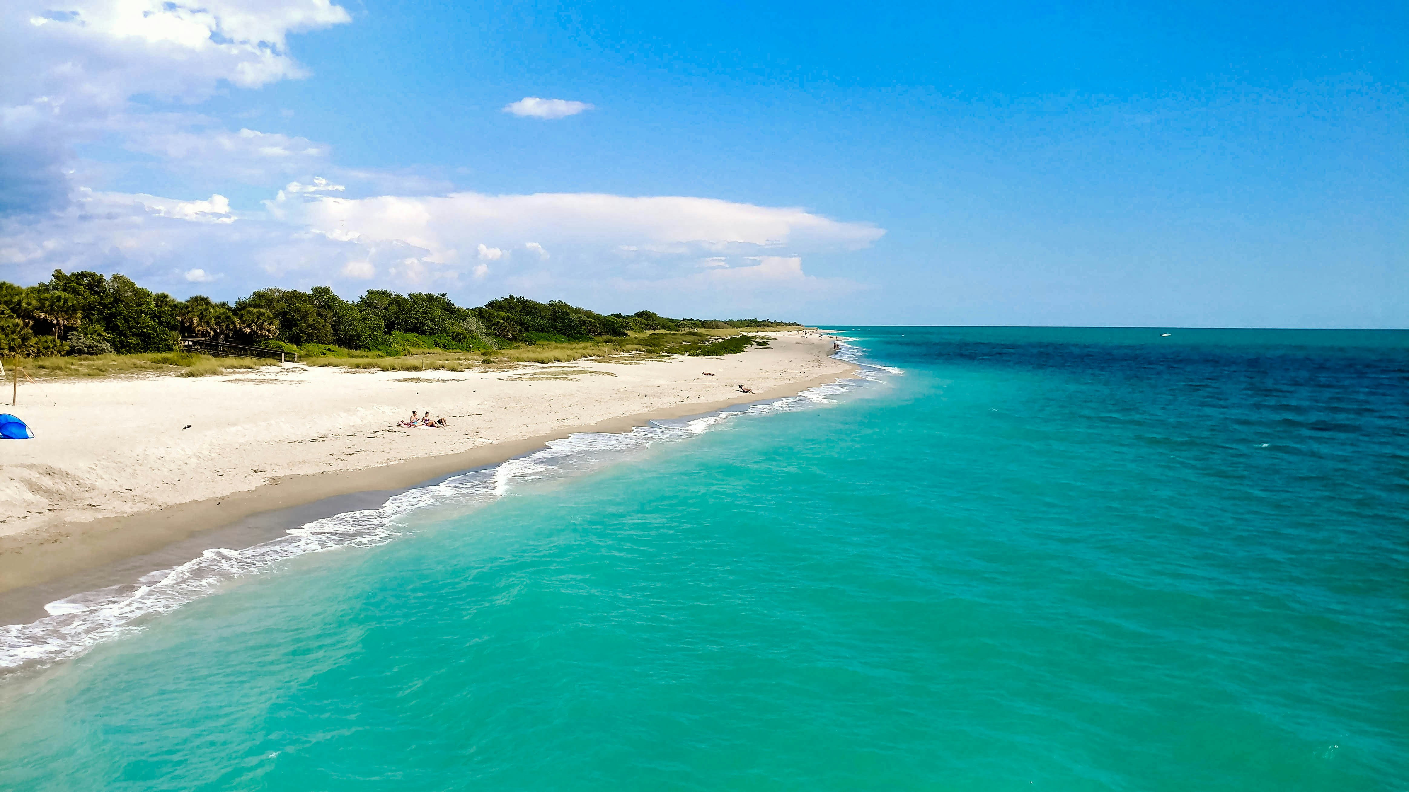 Scenic view of a sandy beach with turquoise water and a clear blue sky
