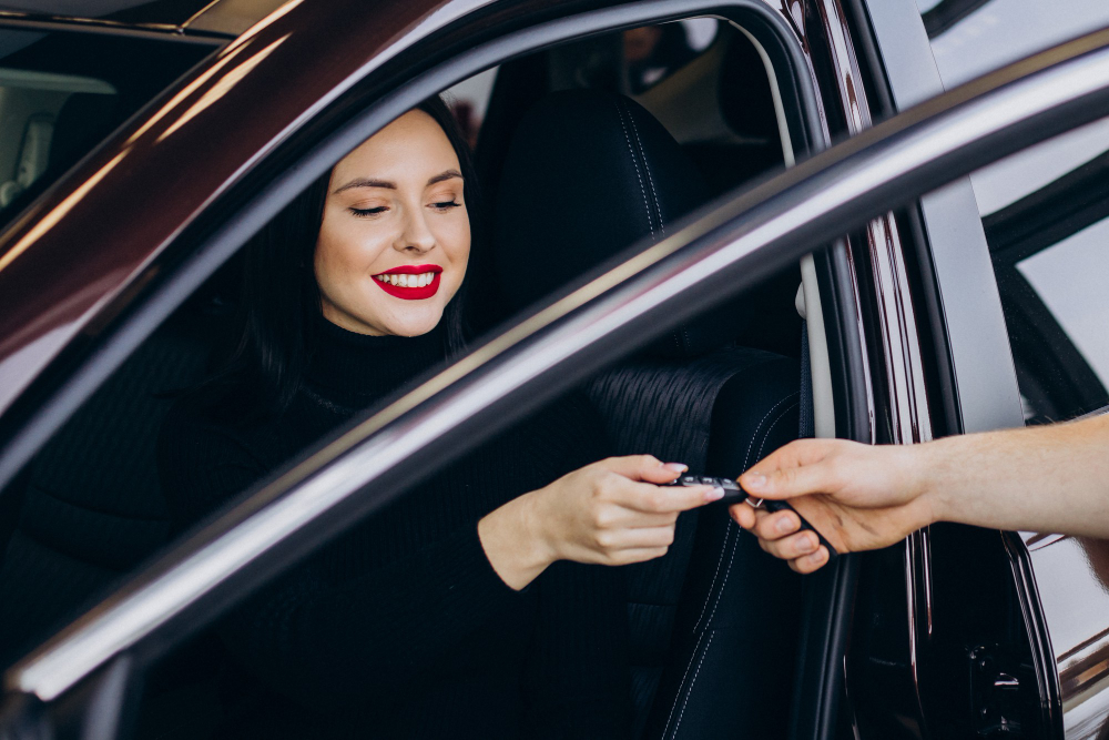 Woman sitting in a car receiving keys from another person