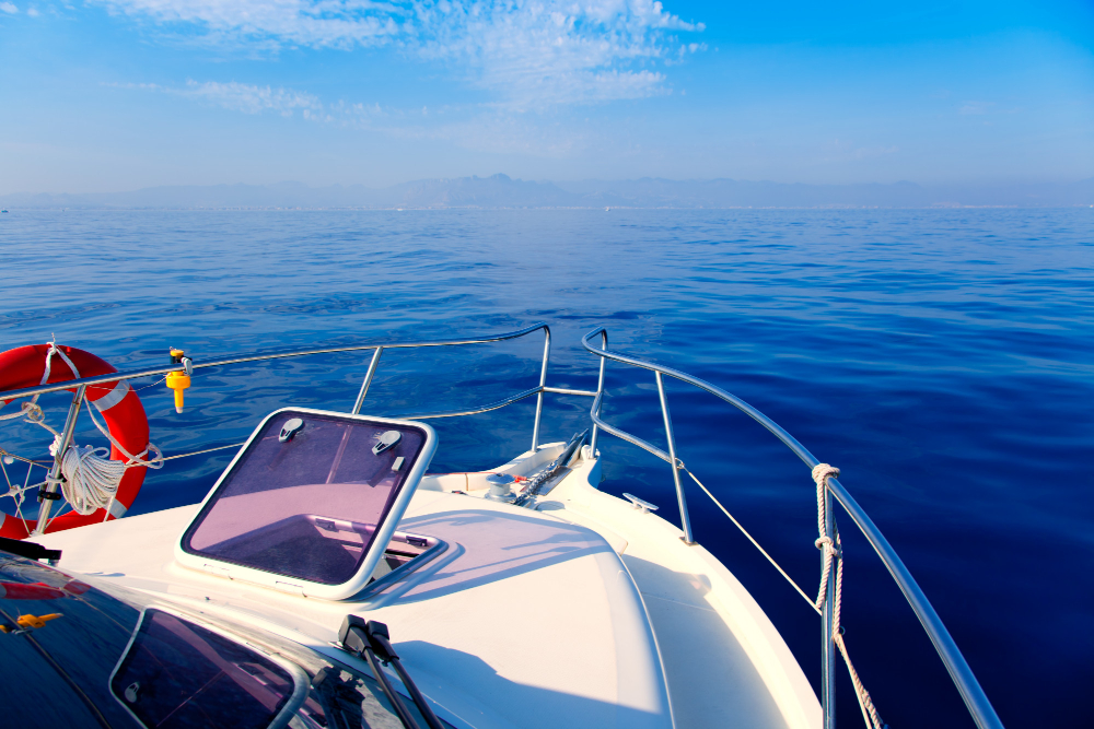 Front view from a boat sailing on a calm blue sea under a clear sky