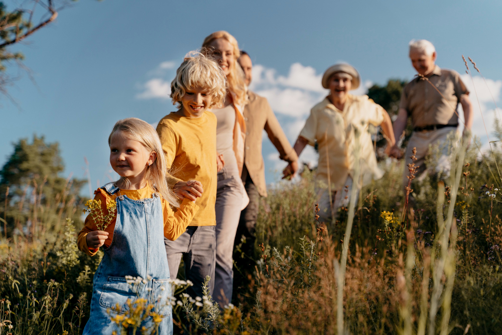 Family walking through a grassy field on a sunny day