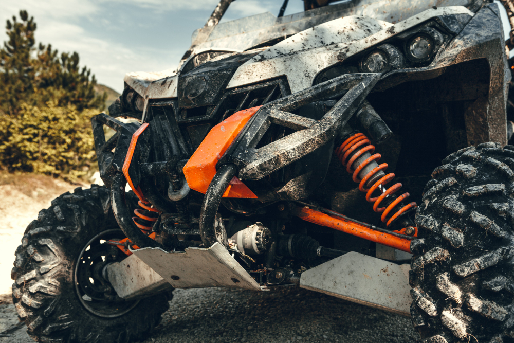 Close-up of a rugged off-road vehicle with muddy tires and suspension