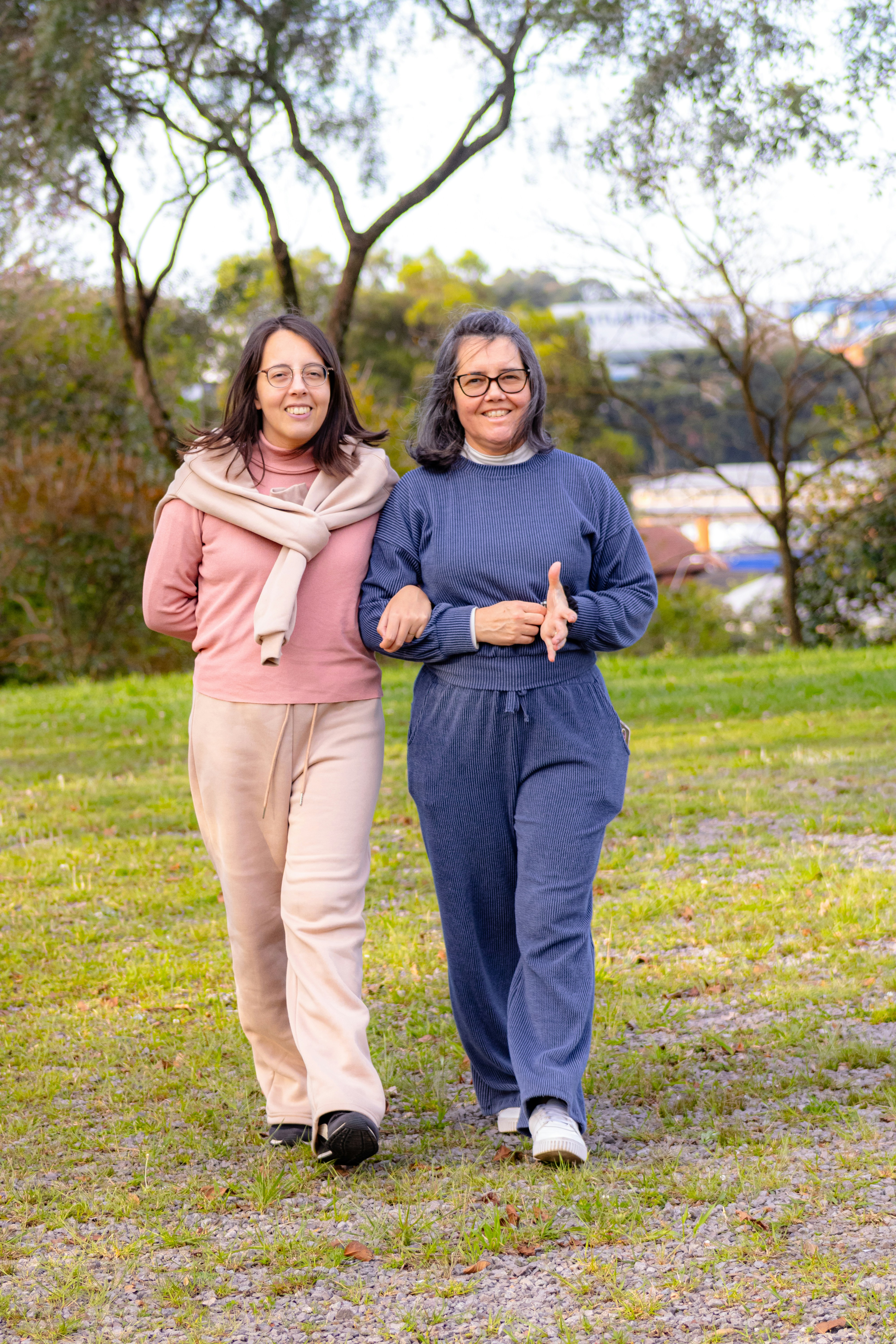 Two people walking together in a park, smiling and enjoying the outdoors