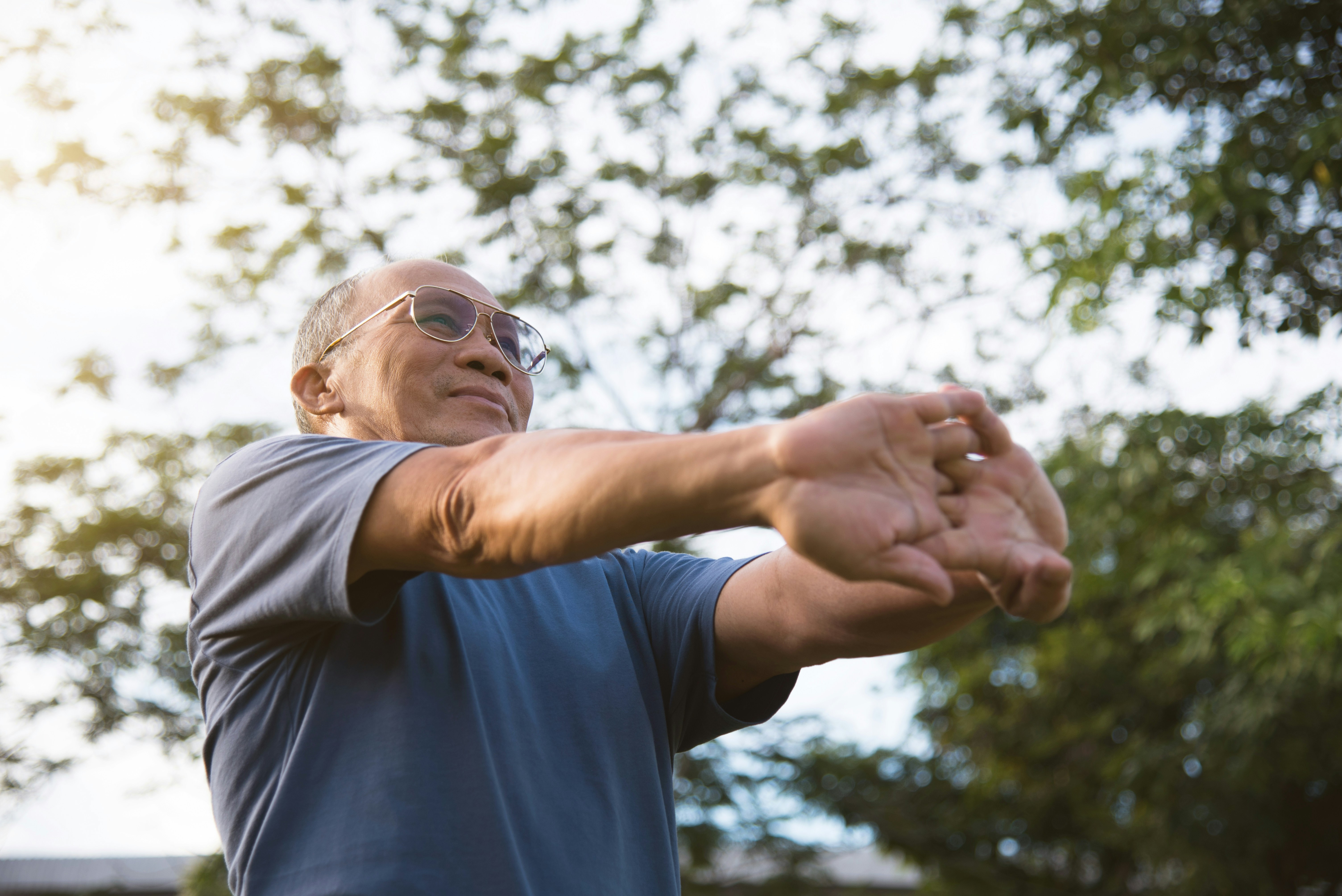 Elderly man stretching outdoors in a park