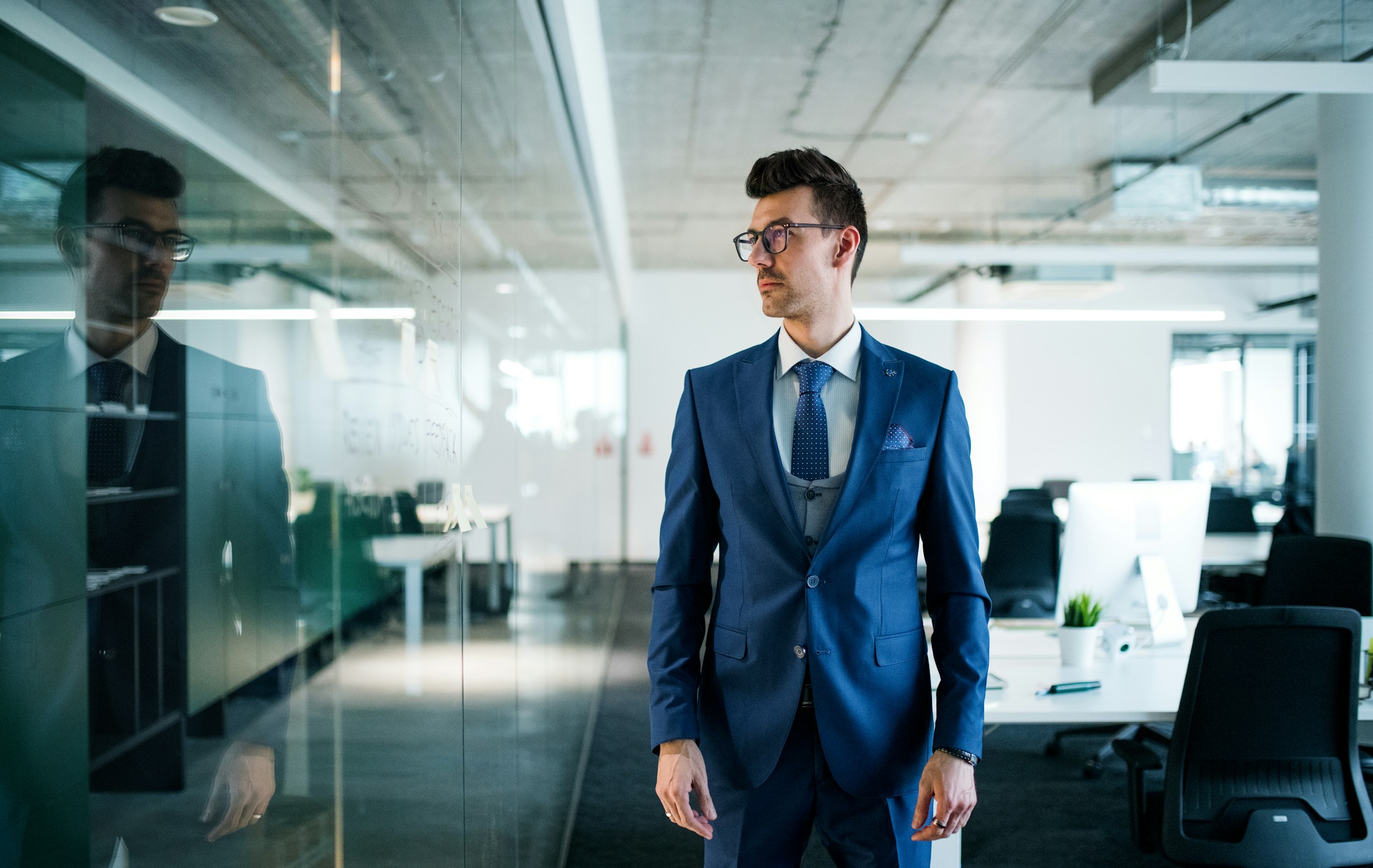 Businessman in a blue suit standing in a modern office
