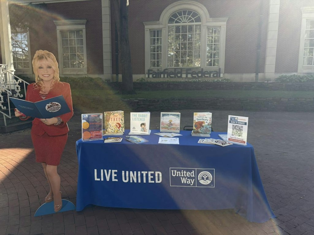 Dolly Parton cutout next to a United Way table with books in front of Fairfield Federal