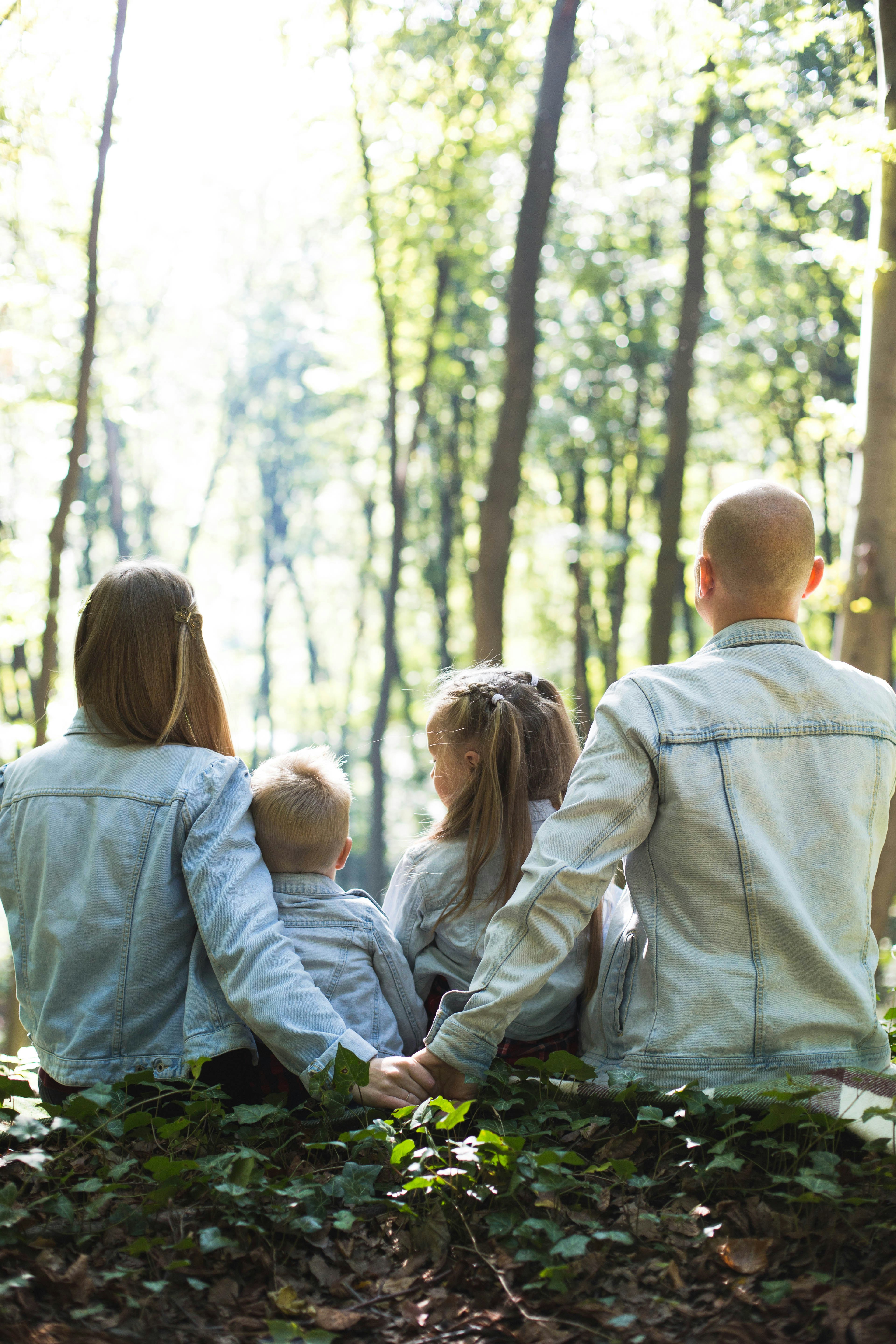 Smiling adult holding a laughing baby outdoors with a woman beside them