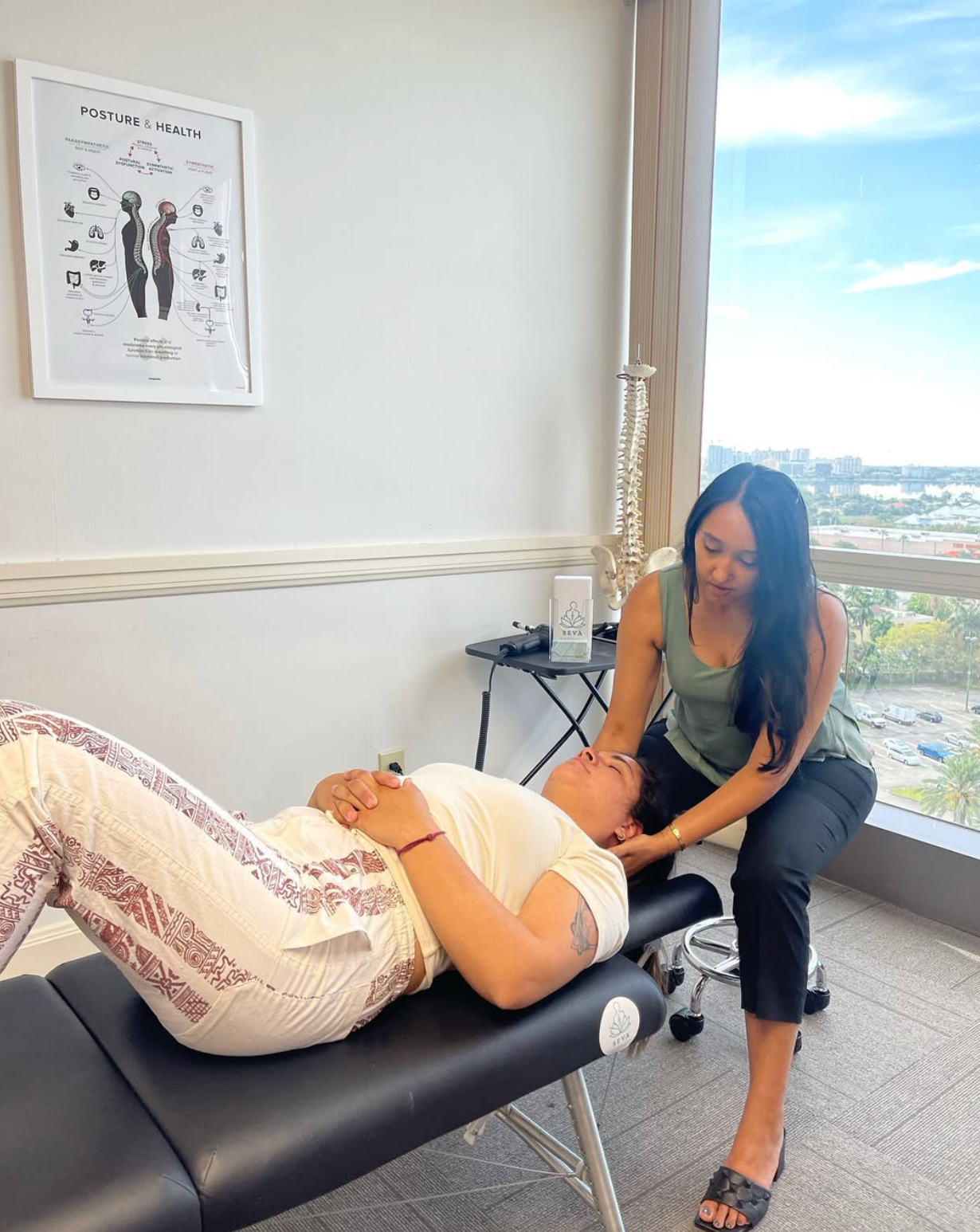 Chiropractor performing neck adjustment on a patient lying on a table in a clinic.