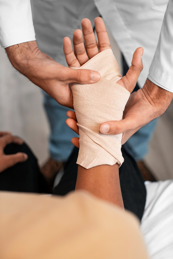 Doctor wrapping a patient's injured hand with a bandage