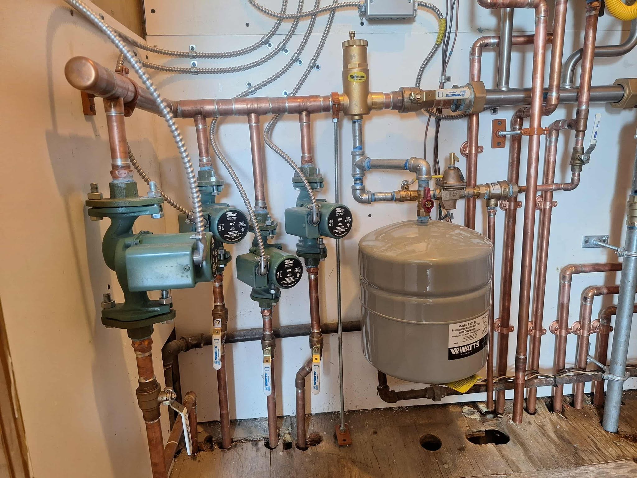 Complex plumbing system with copper pipes and valves in a utility room