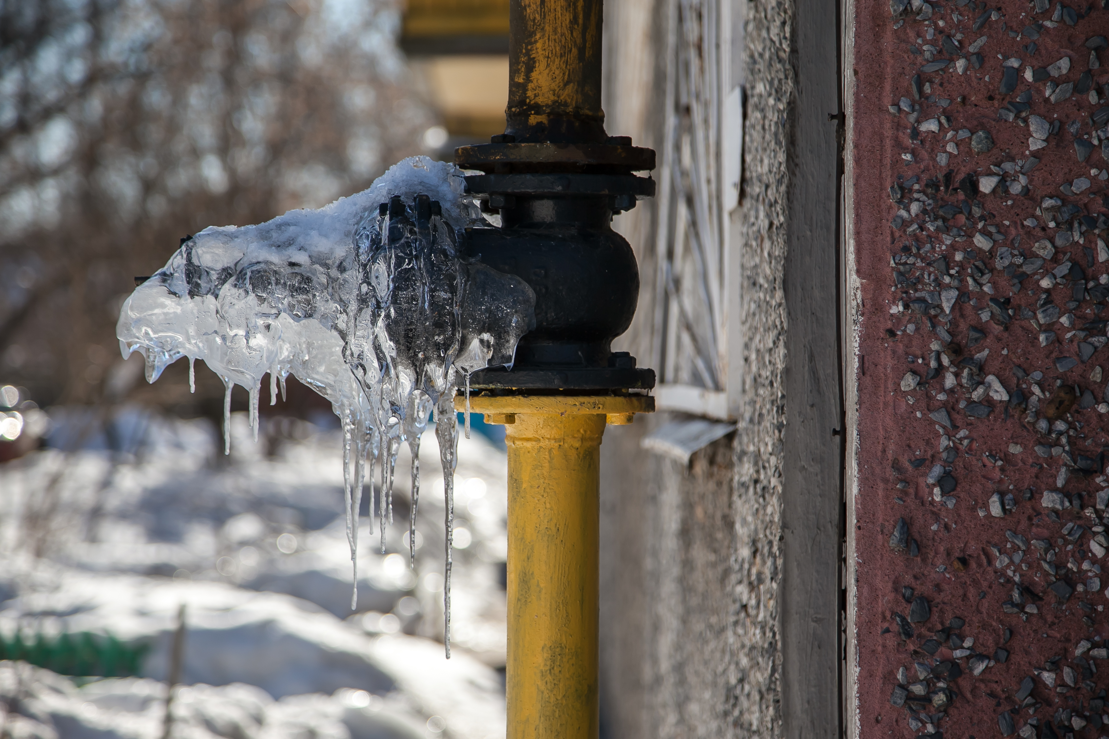 Frozen outdoor pipe with icicles hanging from it