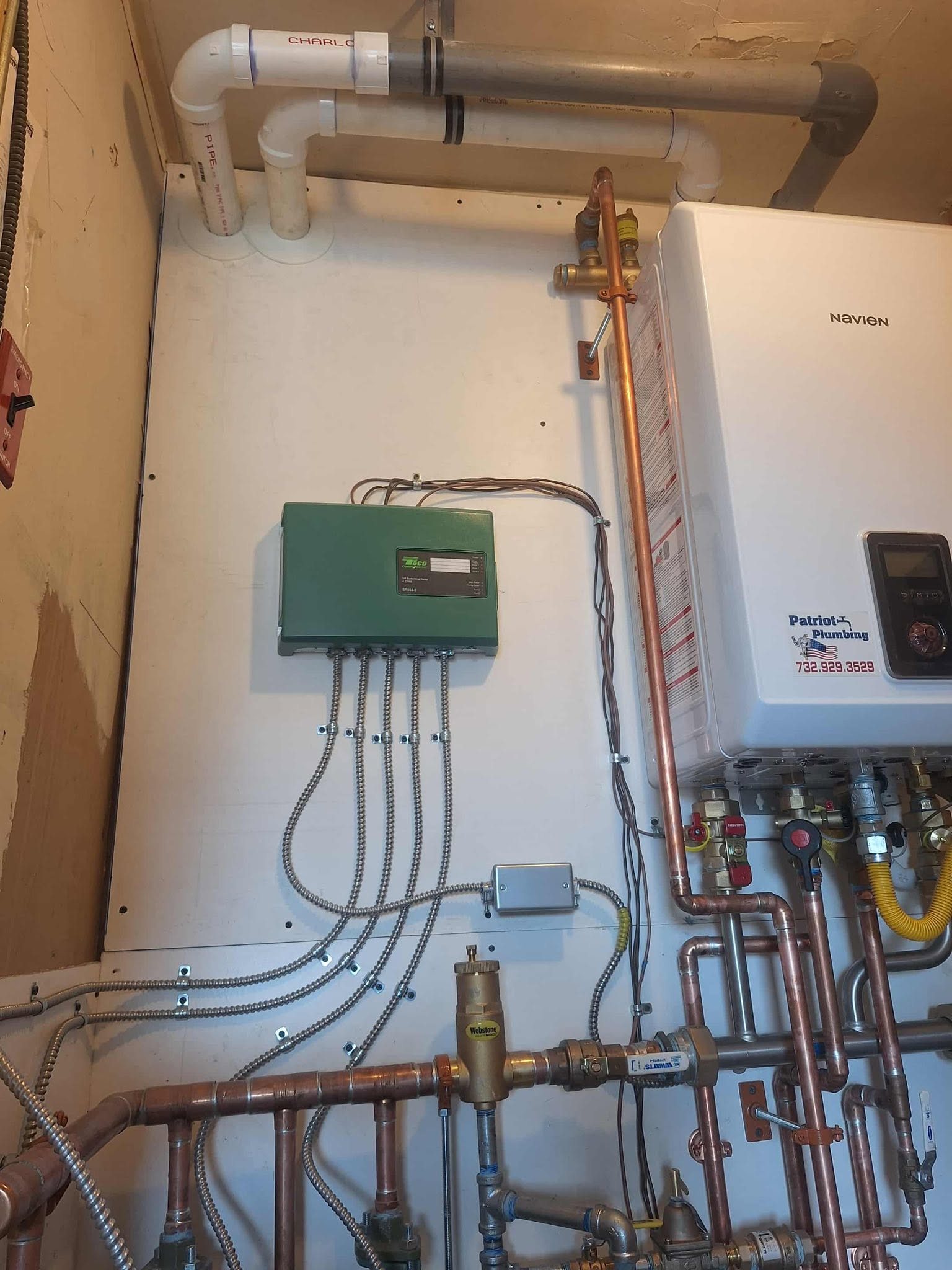 Plumbing system with pipes, control box, and water heater installed on a wall