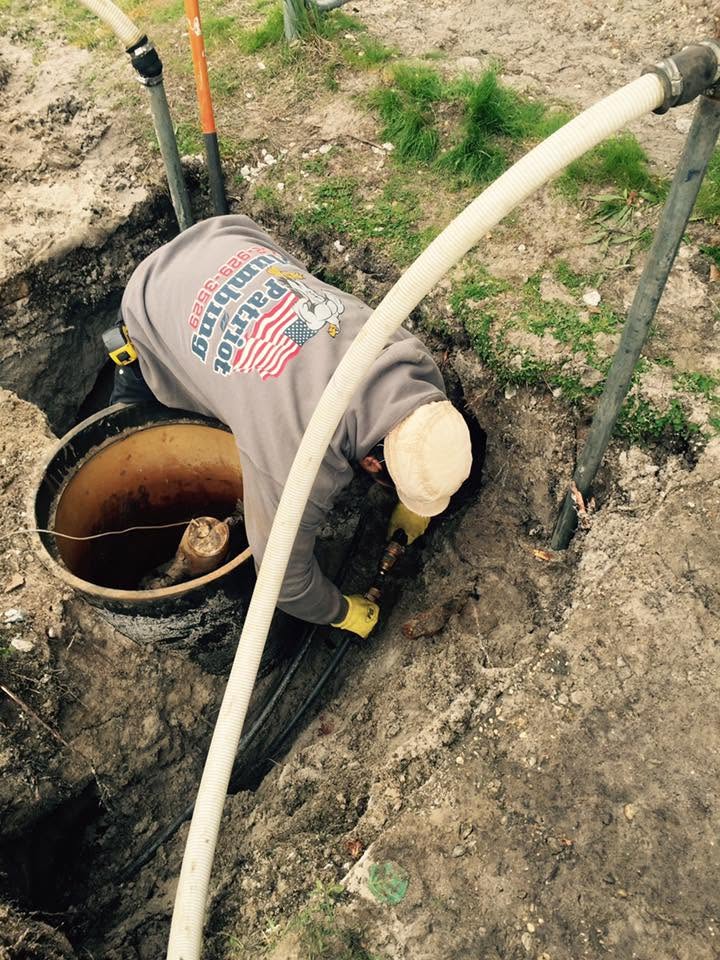 Plumber working on underground pipe connection