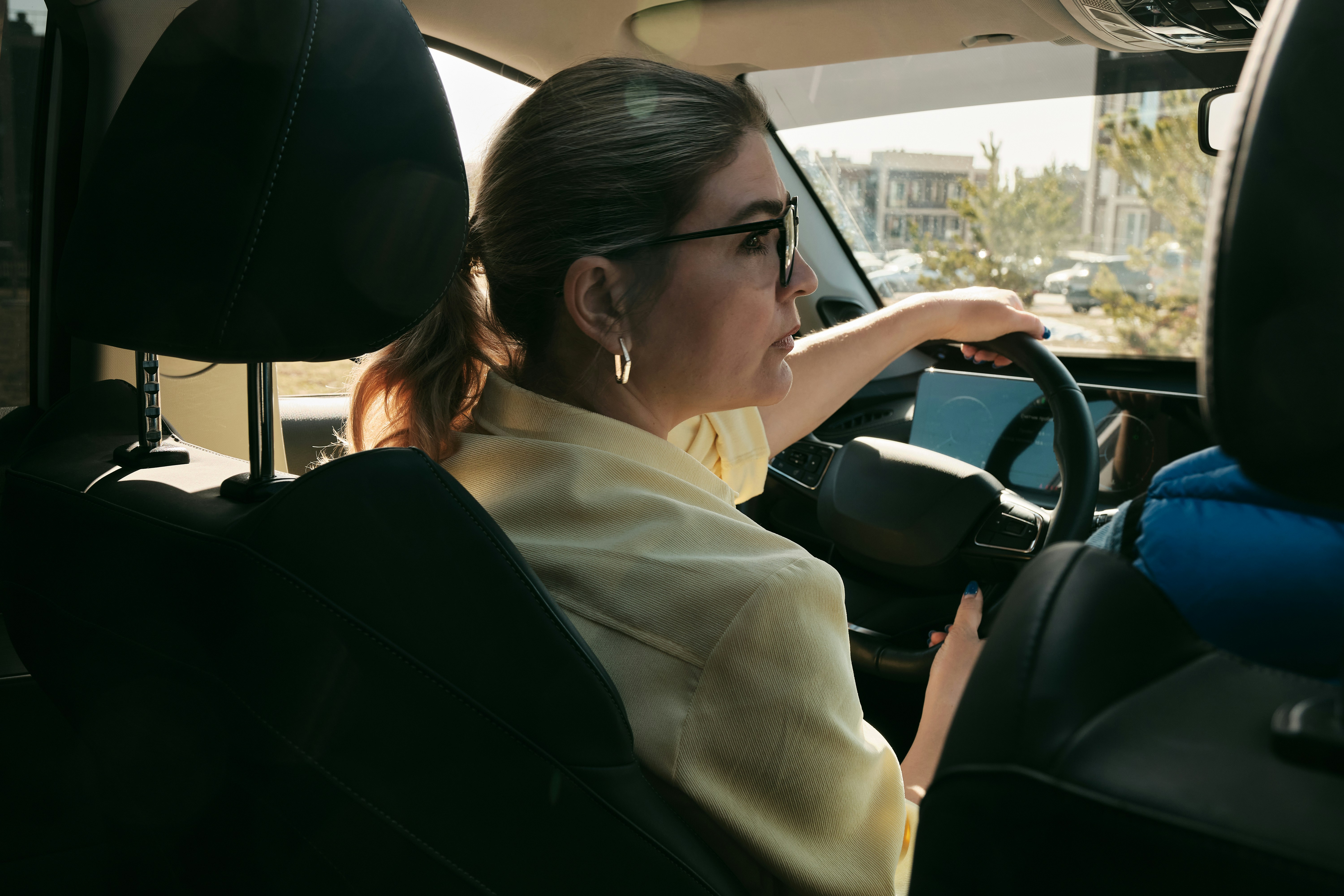 Woman driving a car, viewed from the back seat