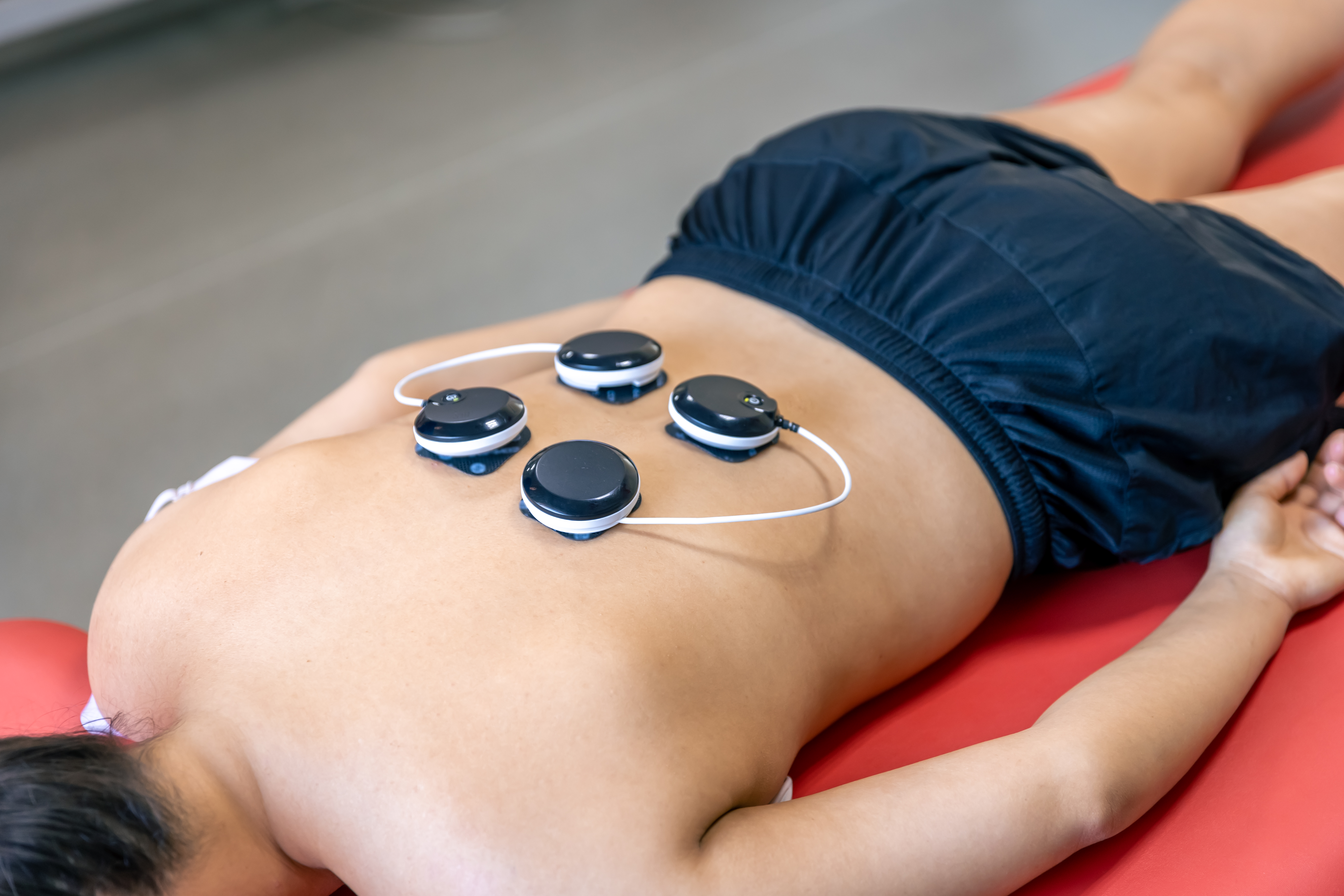 Chiropractor adjusting a person lying face down on a treatment table indoors