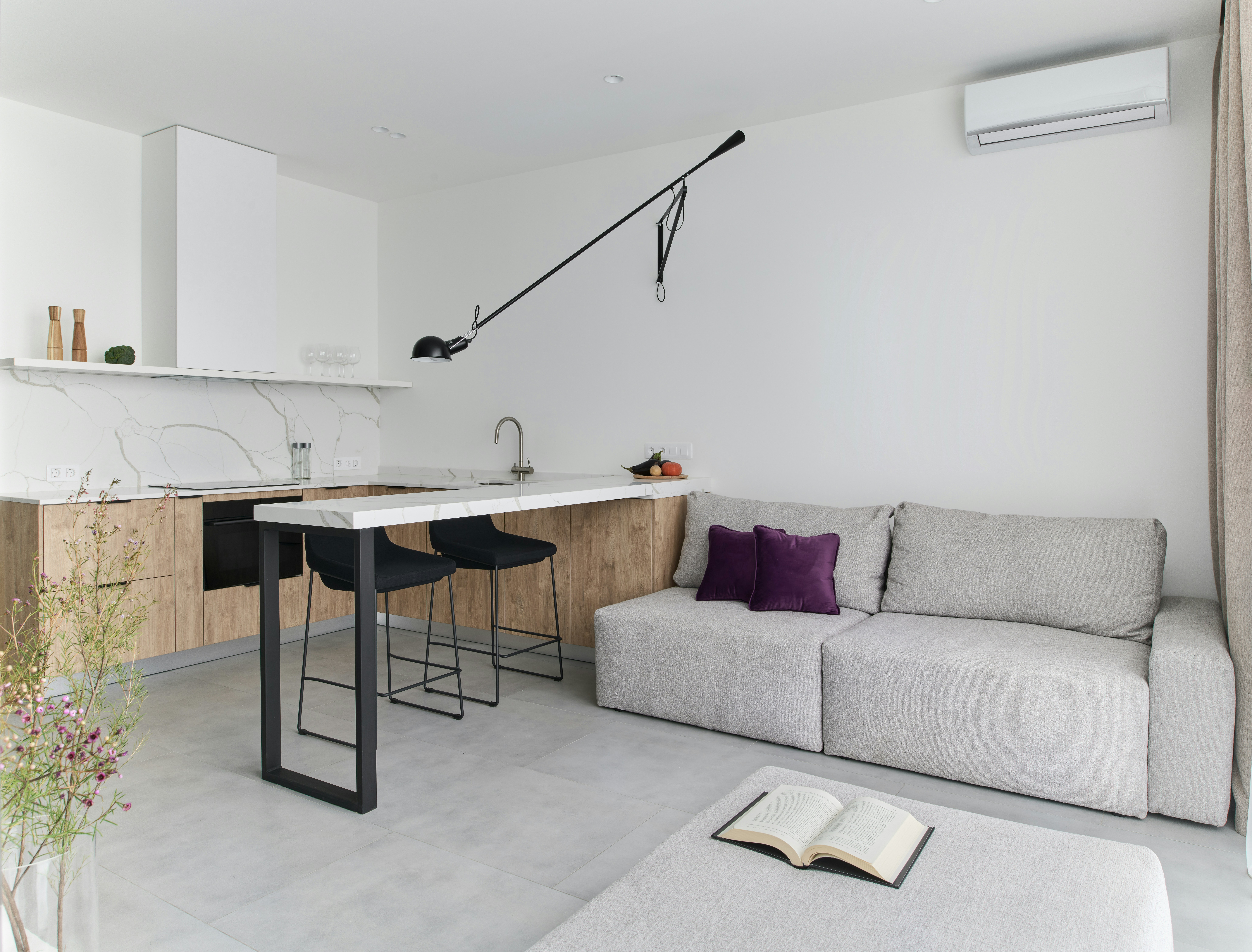 Dining room with wooden table, chairs, cabinet, and artwork. Natural light fills the space.